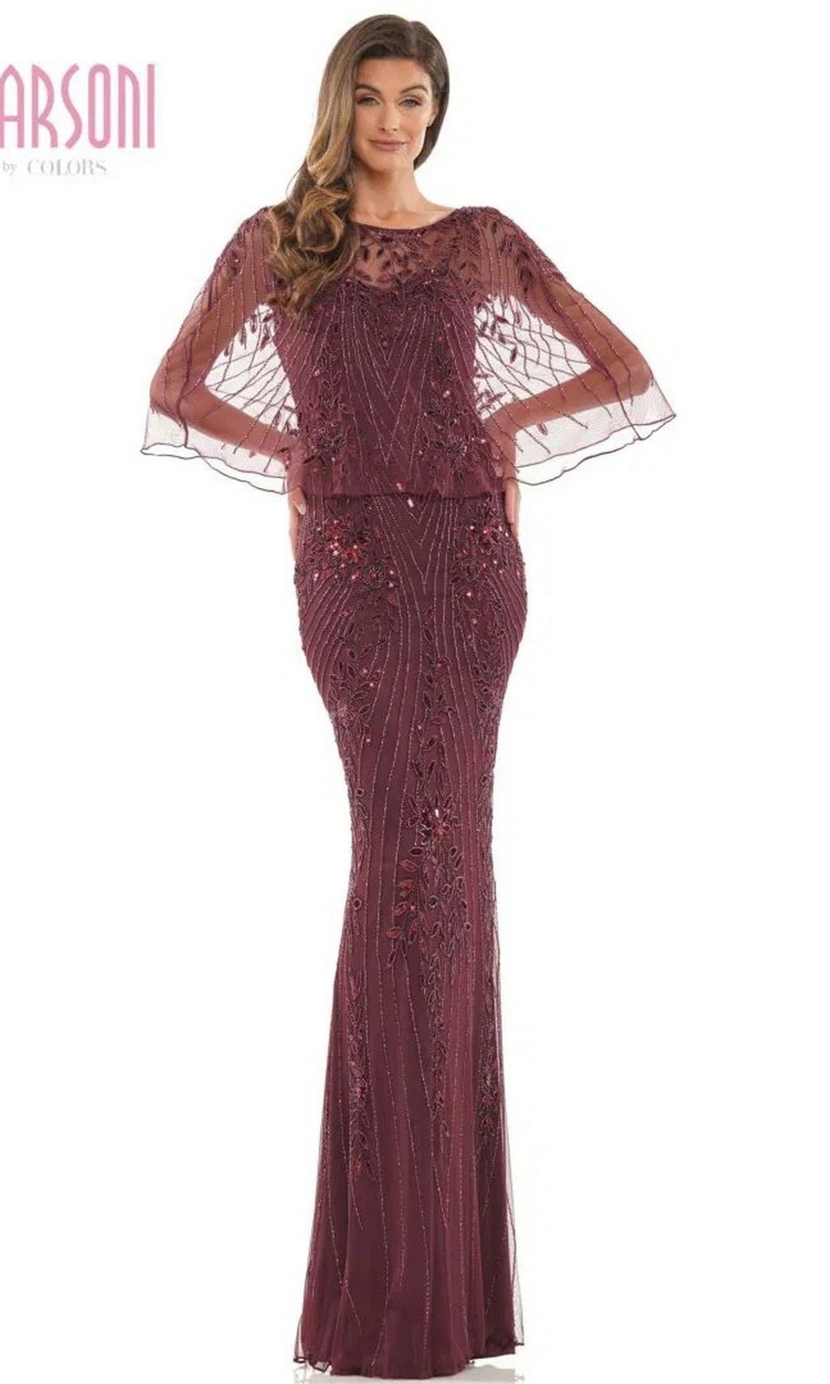 A woman wears the Marsoni MV1201 long formal dress in eggplant, featuring beaded embellishments and sheer, beaded cape sleeves, standing against a plain white background.